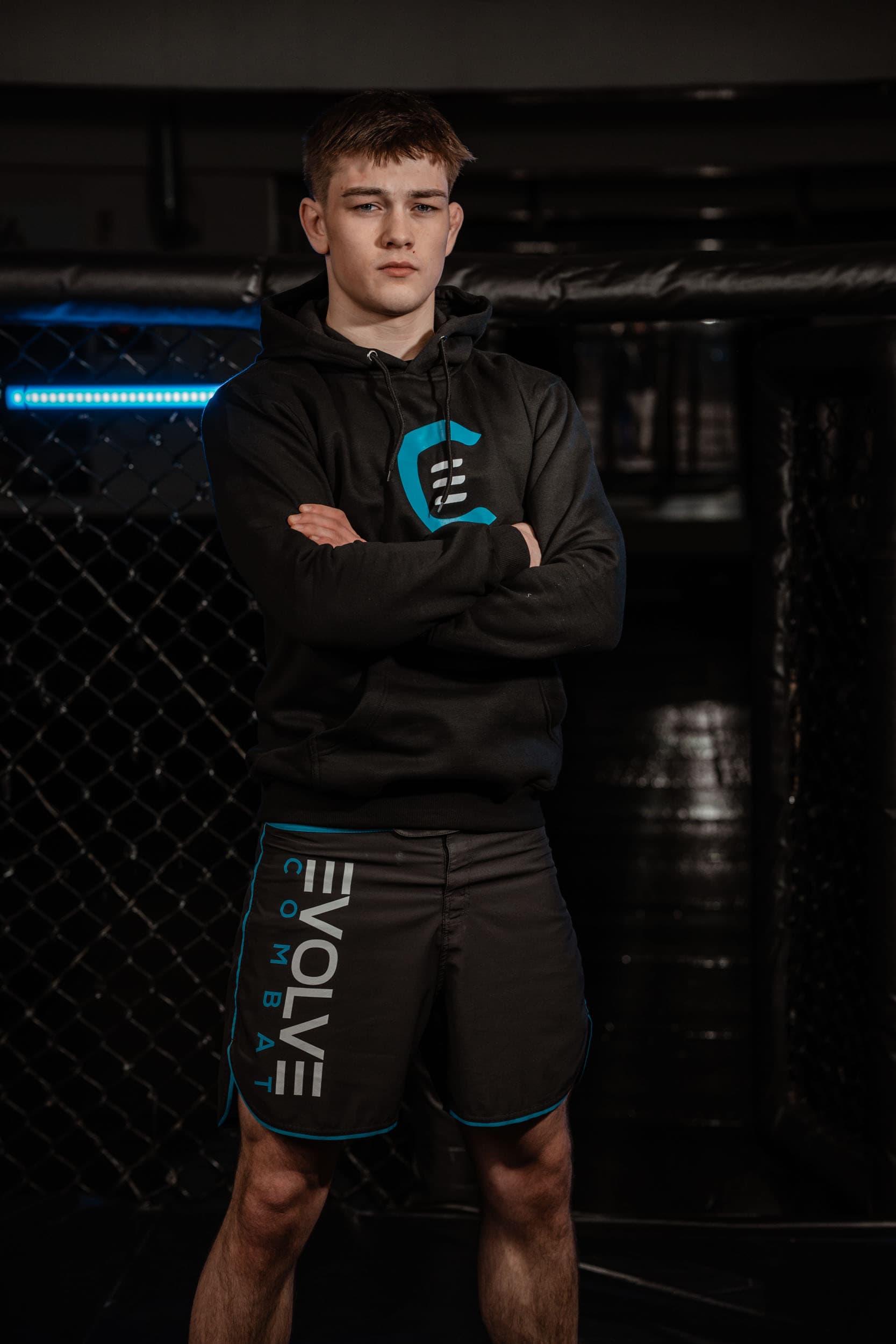 Modell i sort Evolve Combat-hettegenser med armene i kors