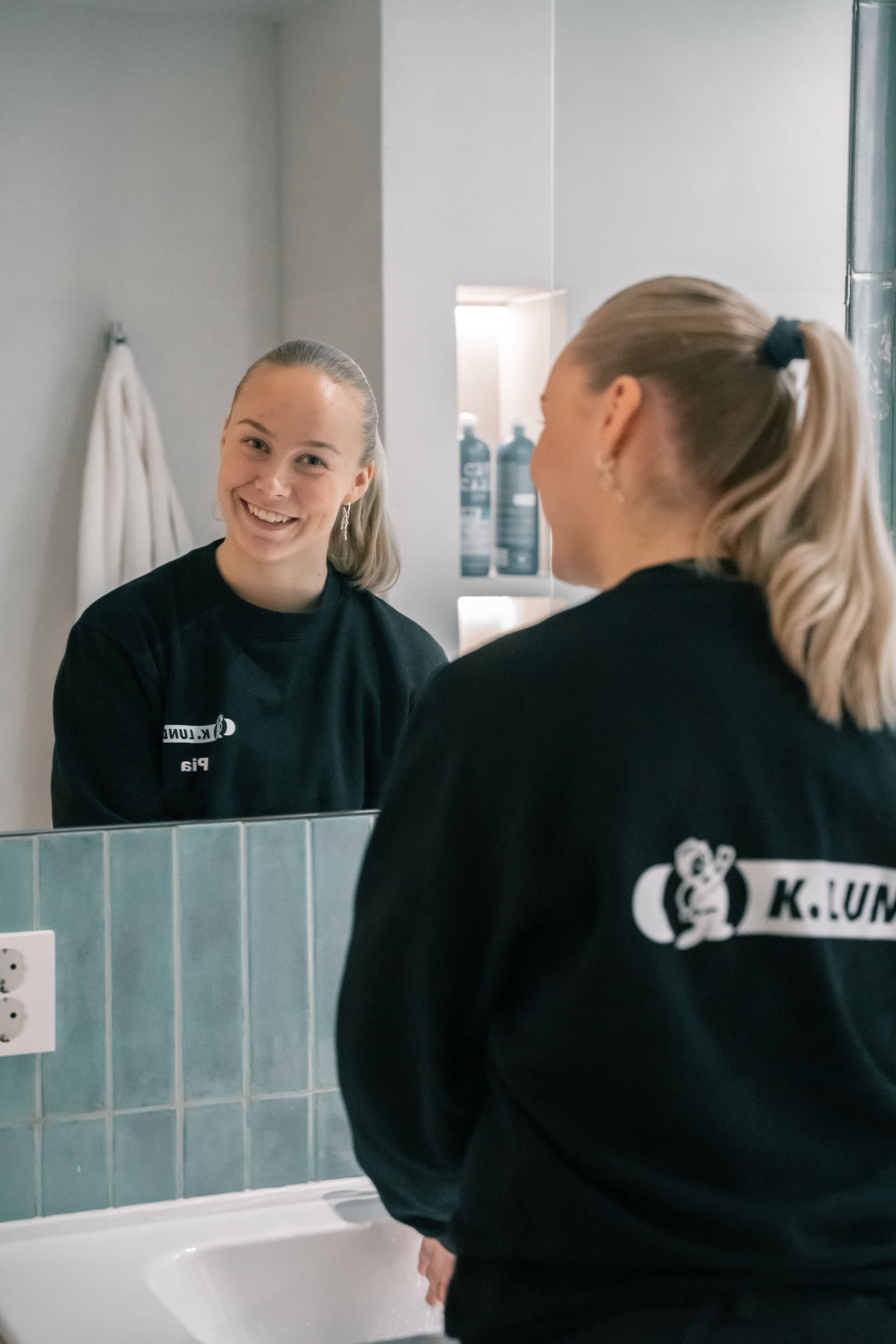 To ansatte i K. Lund-gensere snakker sammen foran speilet på et bad