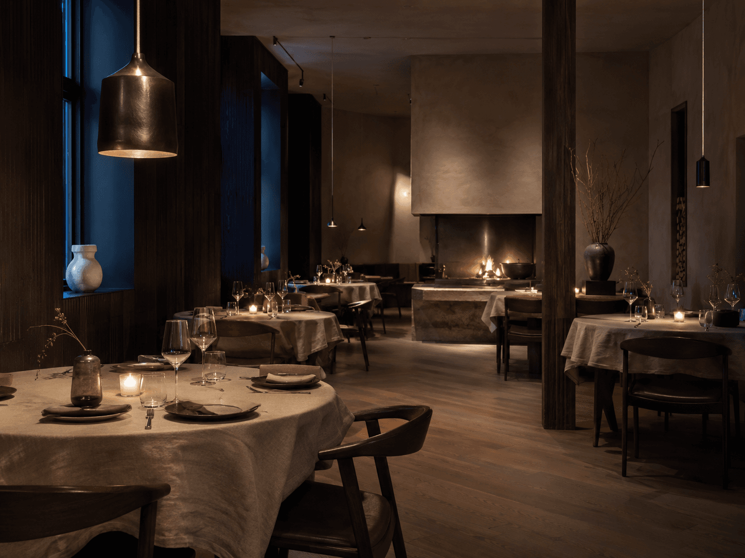 Interiøret i restaurantlokalet på demonettsiden EMBER, med dempet lys og dekkede bord